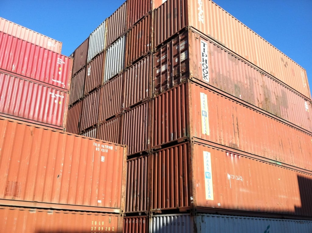 Rows of refurbished corrugated steel used storage containers for sale in a lot