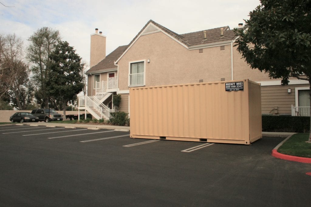 shipping container in parking lot near apartment building