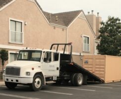 truck delivering storage container to apartment building